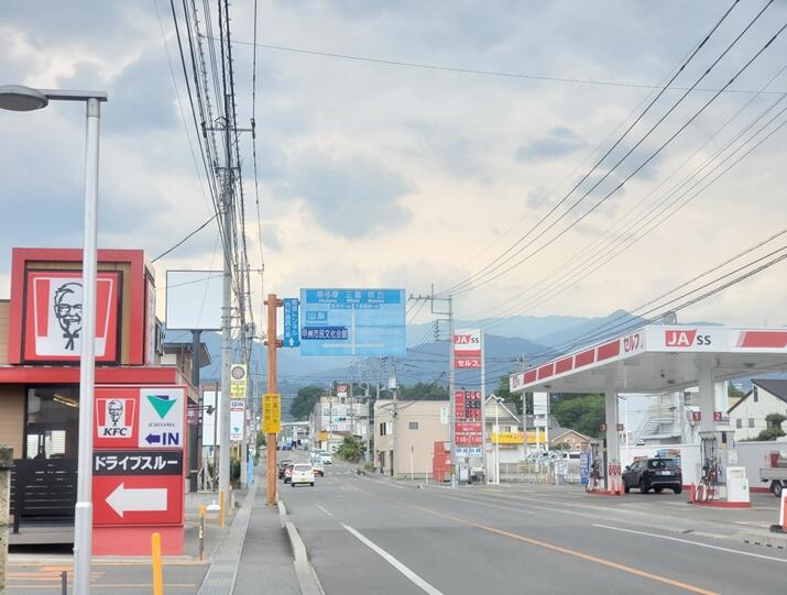 道路沿いにガソリンスタンドや飲食店が並んでいる甲州市内の画像